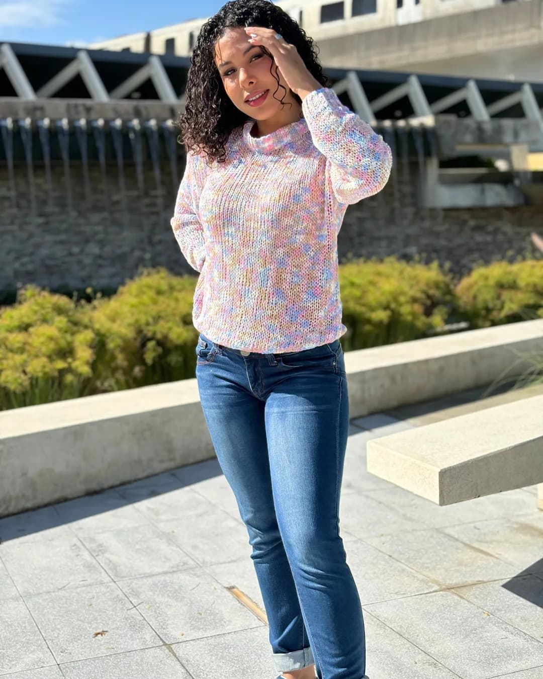 Woman in a pastel space-dyed knit sweater smiling in the sun