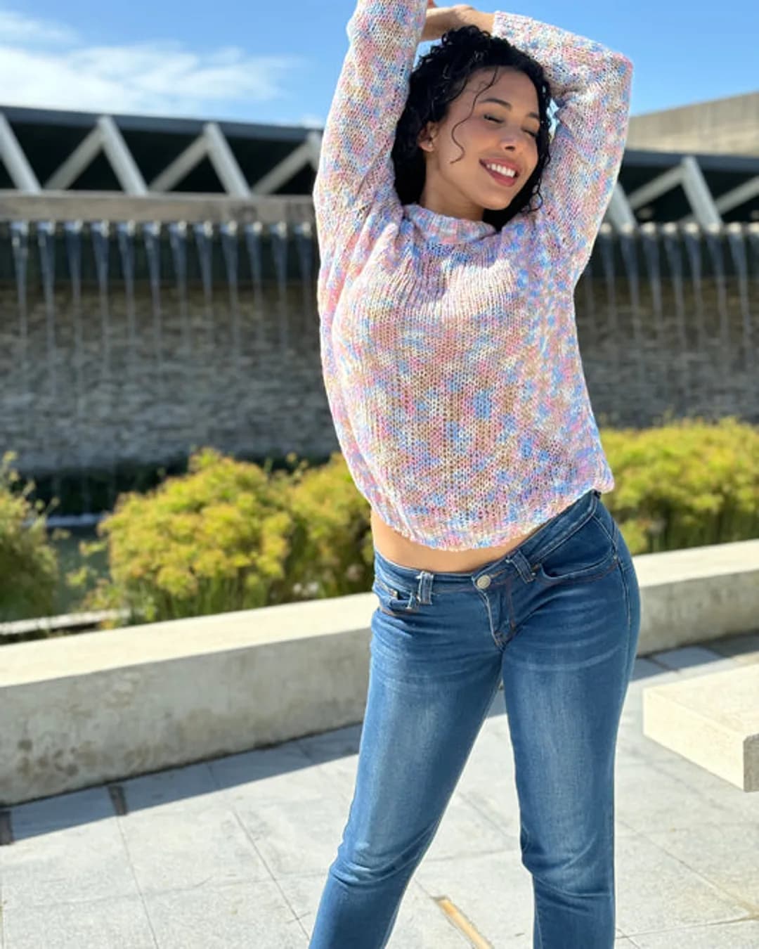 Woman in a pastel space-dyed knit sweater outdoors on a sunny day